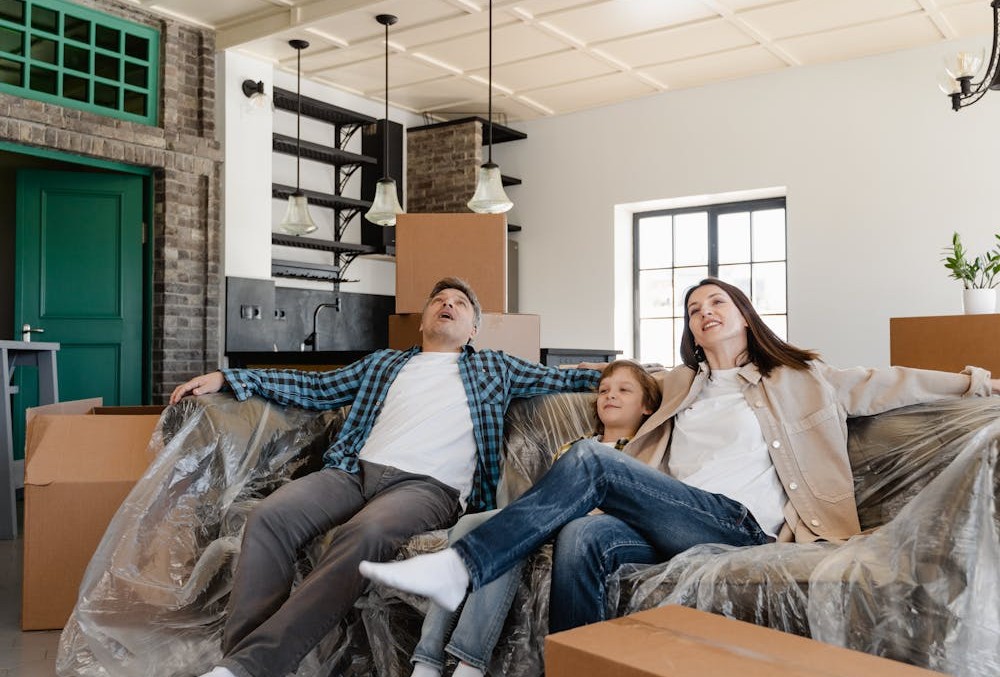 A Family Sitting on Couch Covered with Plastic