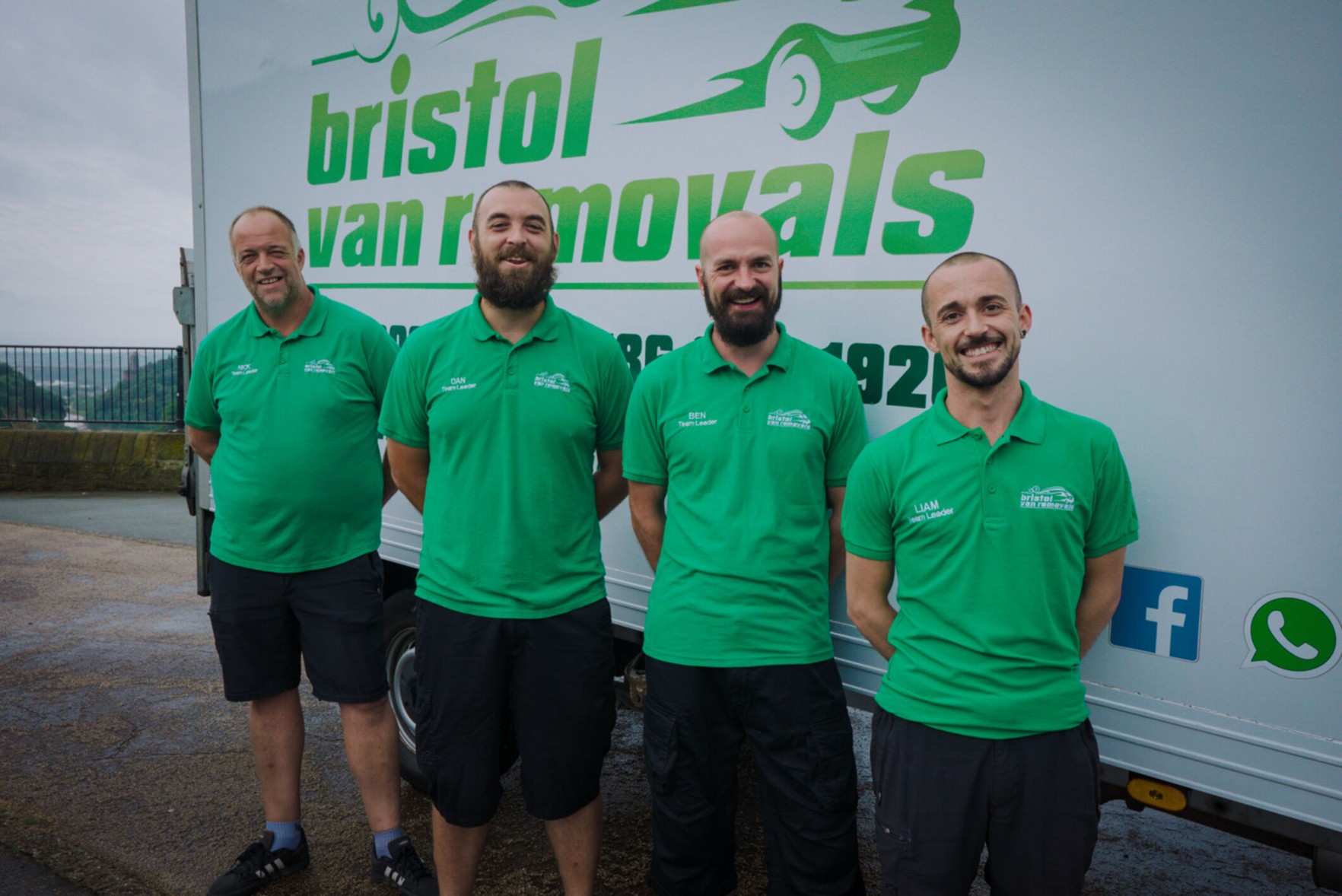 Four members of the Bristol Van Removals team, smiling in front of one of their vans.